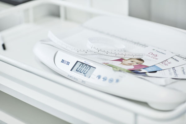 Pile of baby care brochures on scales