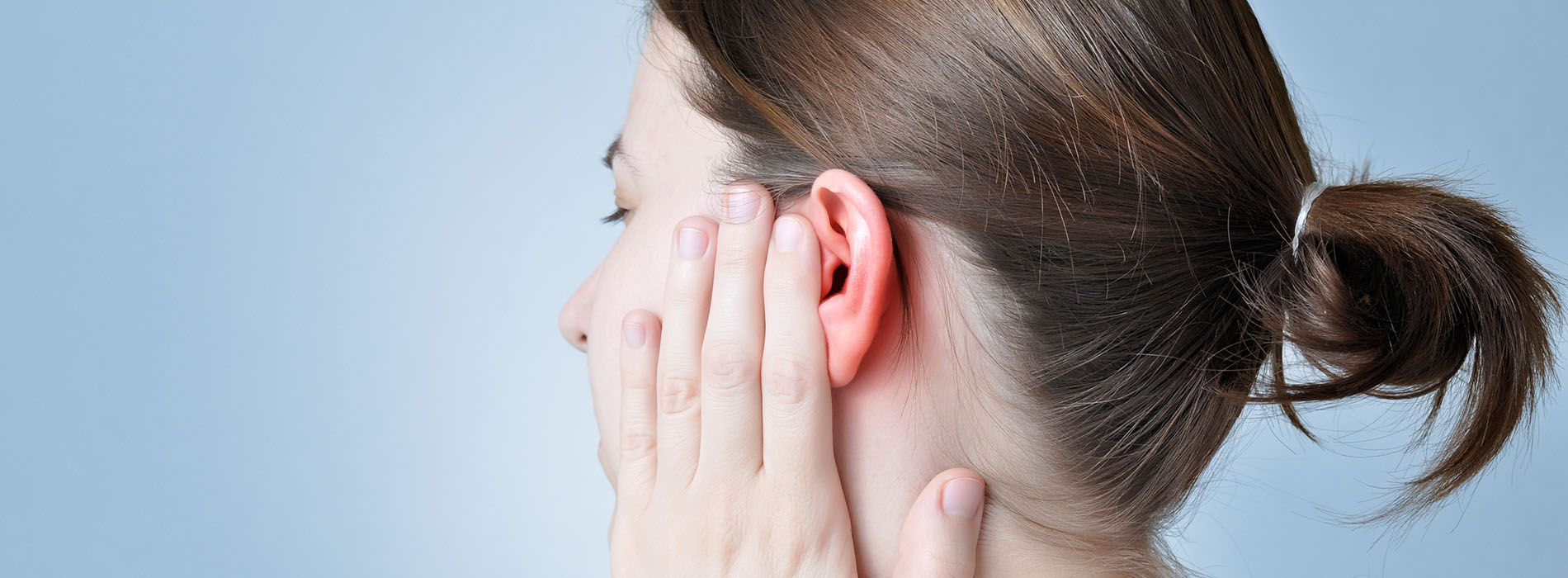 Profile of woman touching her sore ear