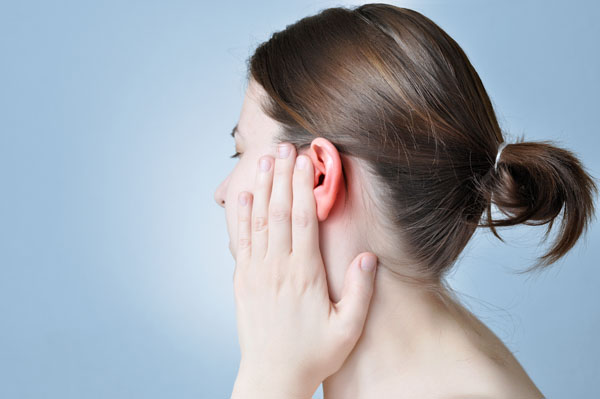 Profile of woman touching her sore ear