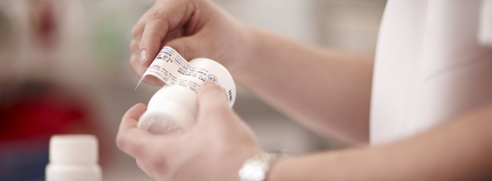Pharmacist placing a label on a prescription bottle